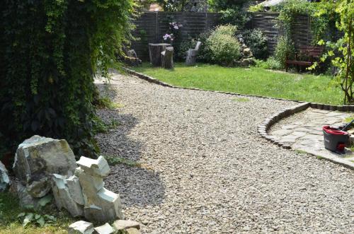 a gravel path in a garden with a bench at Pensiunea Deceneu in Slănic