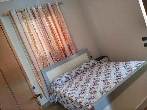 - une petite chambre avec un lit et un rideau dans l'établissement Apartment Demaj, à Vlorë