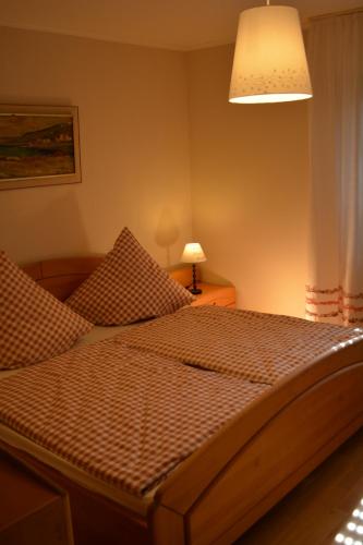 a large bed in a bedroom with a lamp at Kleine Stuga in Windfuß
