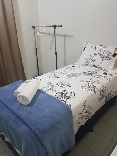 a bed with a black and white comforter and towels at Asa Norte in Brasilia