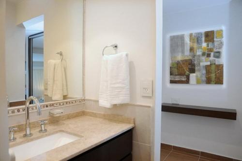 Lake Buenavista Apart Hotel & Suites في فيلا كارلوس باز: حمام مع حوض ومرآة