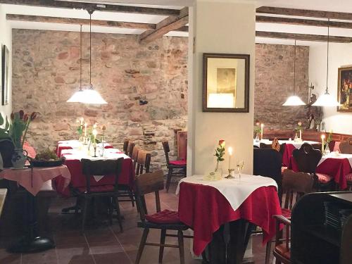 a restaurant with tables and chairs with red table cloth at Romantik Hotel Zur Glocke in Trier