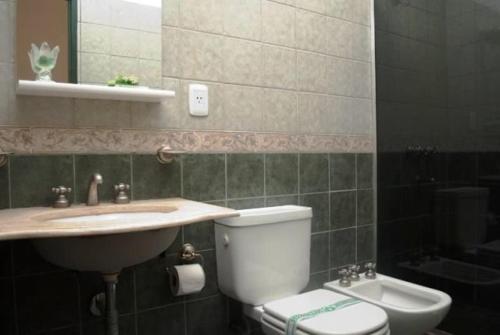 a bathroom with a sink and a toilet and a mirror at Finca La Media Luna in San Agustín de Valle Fértil