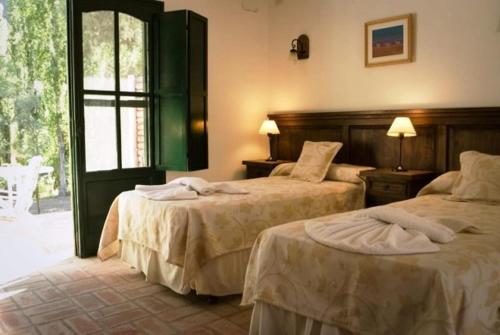 a hotel room with two beds and a window at Finca La Media Luna in San Agustín de Valle Fértil