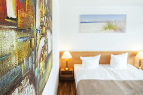 a bedroom with two beds and a painting on the wall at Hotel Plöner See by Tulip Inn in Plön
