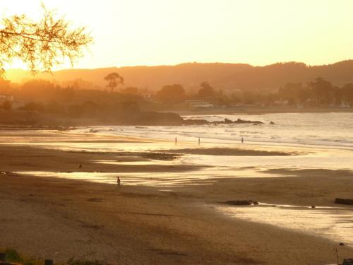 a view of a beach with the sun setting at Mar Del Sueve in Colunga