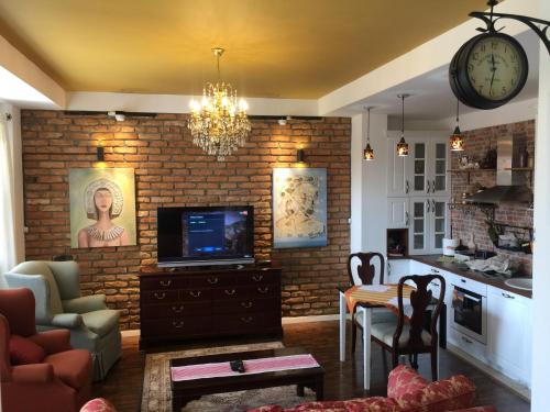 a living room with a tv and a brick wall at Apartment Nesti in Pristina Kosovo in Pristina