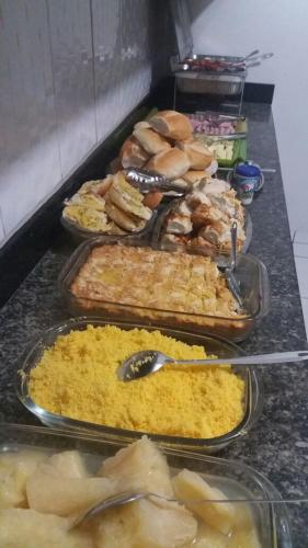een buffet met verschillende soorten eten op de balie bij Hotel Veneza in Garanhuns