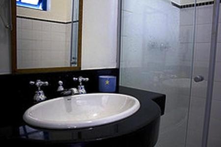 W łazience znajduje się umywalka i przeszklony prysznic. w obiekcie Hotel Fazenda Caco de Cuia w mieście Itabirito