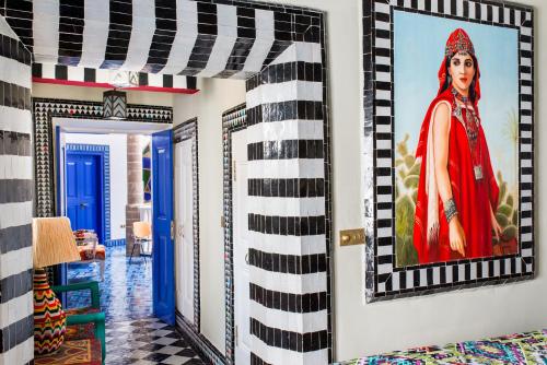 um quarto com uma pintura de uma mulher na parede em Salut Maroc! em Essaouira