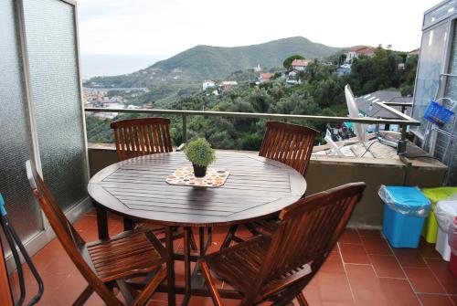 un tavolo in legno con sedie e una pianta in vaso sul balcone di Tigullio Vacations: lo Chalet sul Mare a Leivi