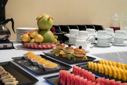 a table topped with trays of food and fruit at Golden Tulip Stone Town Boutique in Zanzibar City