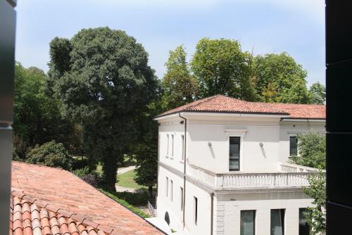 a view of a white building with trees in the background at Residence Eremitani in Padova