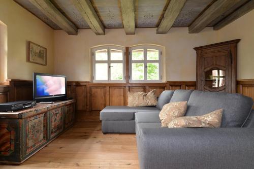 a living room with a couch and a flat screen tv at Les colombages d'a cote in Stetten