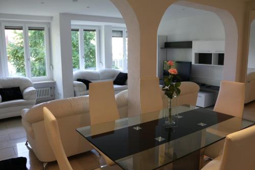 a living room with a glass table and chairs at Ferienwohnung Amperblick Fürstenfeldbruck in Fürstenfeldbruck