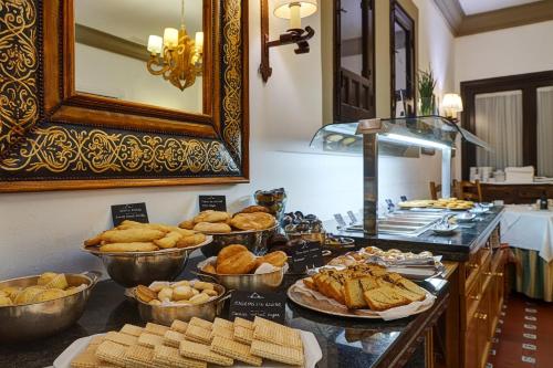 a buffet with bread and pastries on a table at Parador de Ubeda in Úbeda