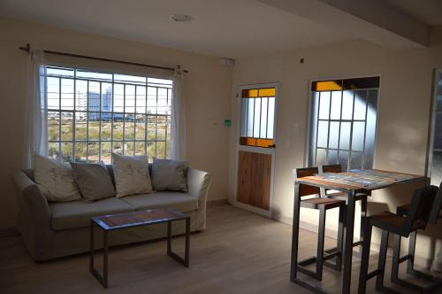 een woonkamer met een bank en een tafel bij Wind Puerto Madryn in Puerto Madryn