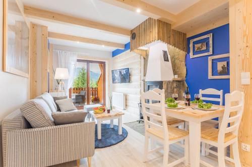 a living room with a table and a dining room at Apartamenty Rockus LUX & SPA Zakopane in Kościelisko