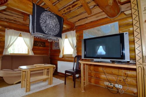 a living room with a tv in a log cabin at Resort Svět in Úžice