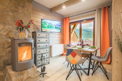 コシチェリスコにあるApartamenty Rockus LUX & SPA Zakopaneのリビングルーム(暖炉、テーブル、椅子付)