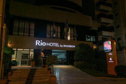 a hotel sign in front of a building at night at Rio Hotel by Bourbon Curitiba in Curitiba