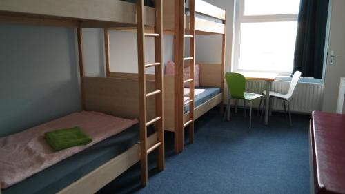 a bedroom with bunk beds and a table and a window at Hostel Inn-Berlin in Berlin