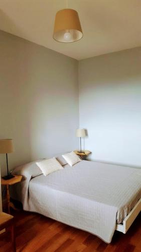 a bedroom with a large white bed with two lamps at B&B Sophia in Santa Sofia dʼEpiro