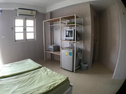 a small room with a bed and a television at Roof View Place in Bangkok
