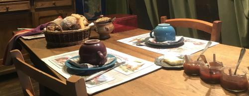 a wooden table with plates and a basket on it at Chambre d'Hôtes chez Nadine Hamm in Weiterswiller