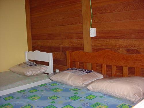 ガロパバにあるTranquilidade na Praia da Gamboaの木製の壁のベッドルーム1室(ベッド2台付)