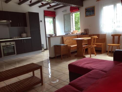 a living room and kitchen with a couch and a table at Meublé de tourisme "Au bord de la Mare" in Salazie