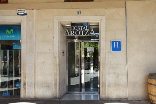 a building with a sign on the door of it at Hostal Arotza in Tafalla