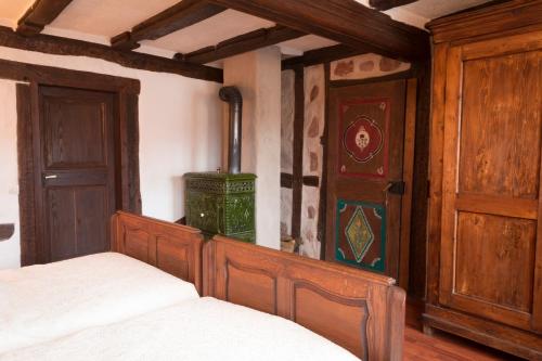 1 dormitorio con cama de madera y puerta de madera en Chambre d'Hôtes chez Nadine Hamm, en Weiterswiller