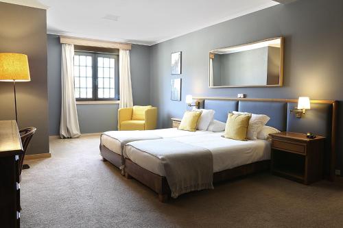 a bedroom with a large bed and a mirror at Cosy Sintra in Sintra