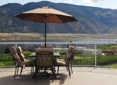 a table and chairs with an umbrella on a patio at Ciliegia Villa in Osoyoos