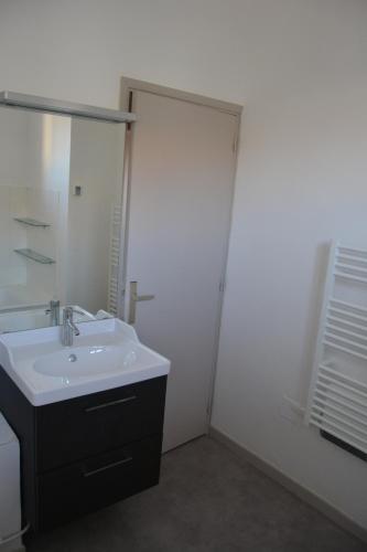 une salle de bain blanche avec un lavabo et un miroir dans l'établissement Appartement Garance, à Avignon