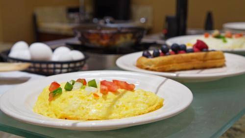 a table topped with plates of food with eggs and fruit at The Florida Hotel & Conference Center in the Florida Mall in Orlando