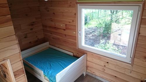 Cette petite chambre se trouve dans une cabane en rondins dotée d'une fenêtre. dans l'établissement La cabane de Denier, à Denier