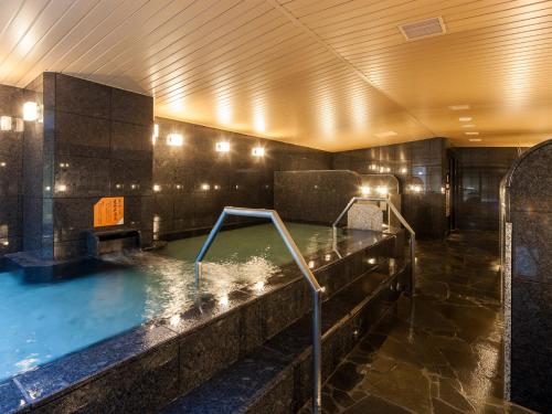 a large pool of water in a hotel bathroom at APA Hotel Sugamo Ekimae in Tokyo