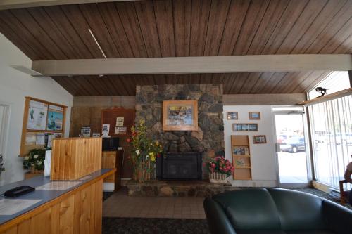 a living room with a fireplace and a stone wall at Dude & Roundup in West Yellowstone