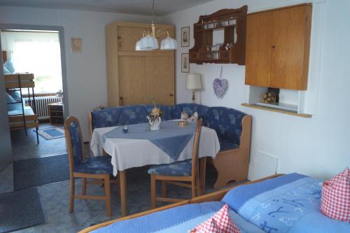 a dining room with a table and blue chairs at Pension Jagdhütte in Sankt Andreasberg