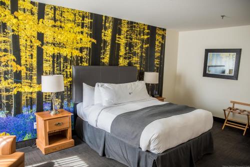 a hotel room with a bed and a wall mural at L'Auberge Du Lac St-Pierre in Trois-Rivières