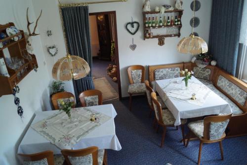 a dining room with two tables and chairs at Pension Jagdhütte in Sankt Andreasberg