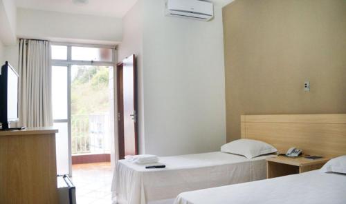 En eller flere senge i et værelse på Manhuaçu Center Hotel
