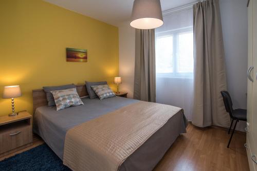 ein Schlafzimmer mit großem Bett und Fenster in der Unterkunft Apartments Sanjin in Kornić