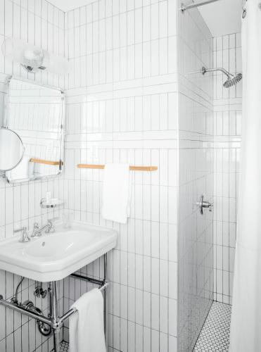 a white bathroom with a sink and a shower at Sound View Greenport in Greenport