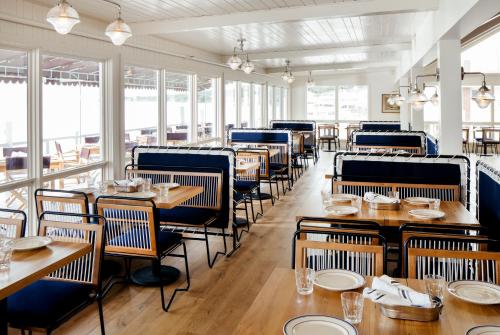 a dining room with tables and chairs and windows at Sound View Greenport in Greenport