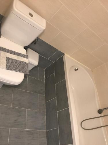 a bathroom with a toilet and a tile floor at Hotel Rex in Thessaloniki