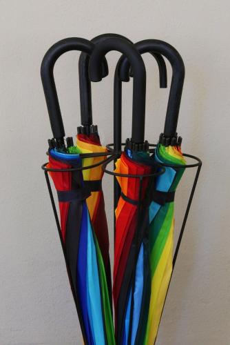 three rainbow colored umbrellas hanging from a wall at Cosy Sintra in Sintra