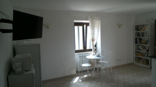 a living room with a table and chairs and a window at Cominium Benessere in Alvito